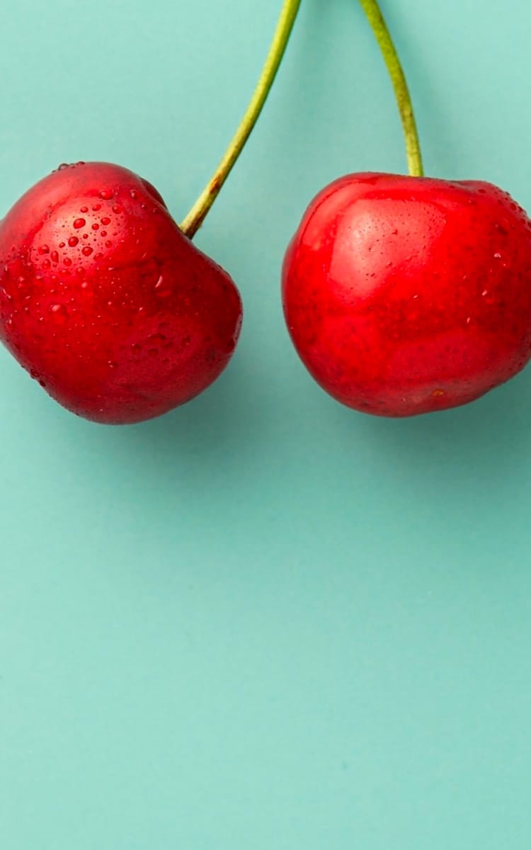 Red cherry on green background